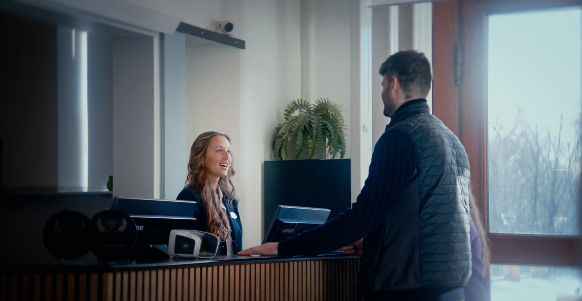 To gæster der bliver modtaget af hotellets receptionist