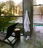 Udendørs spaområde med dampende pool og træer
