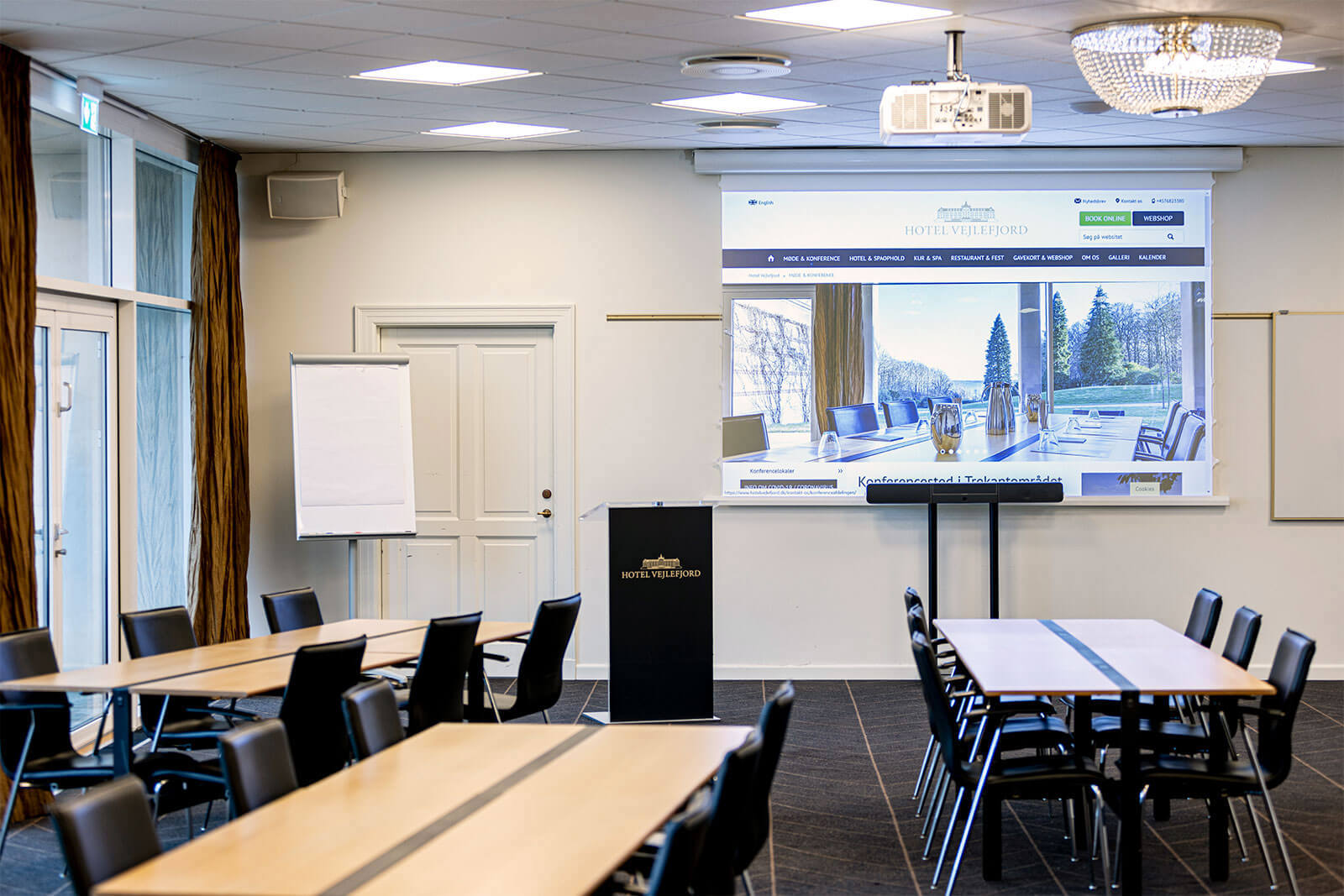 Krystalsalen mødelokale opstillet i skoleborde mod tavle og lærred