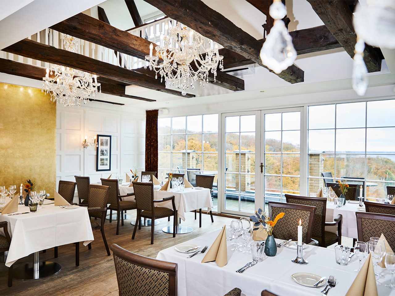 Smuk restaurant med smukke lysekroner og hanebjælker - samt en flot udsigt over Vejle Fjord