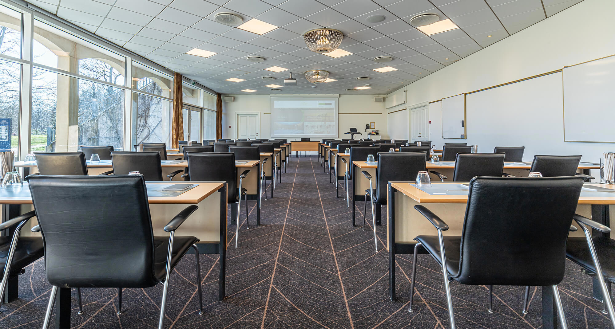 Konferencelokale med borde og stole klar til møde