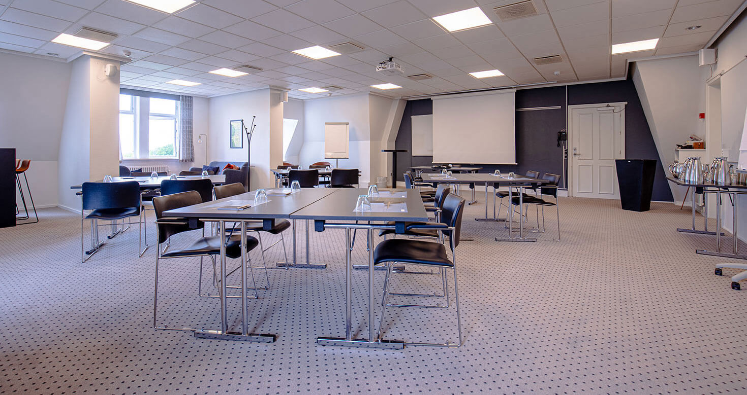 Konferencelokale med borde opstillet i grupper eller øer