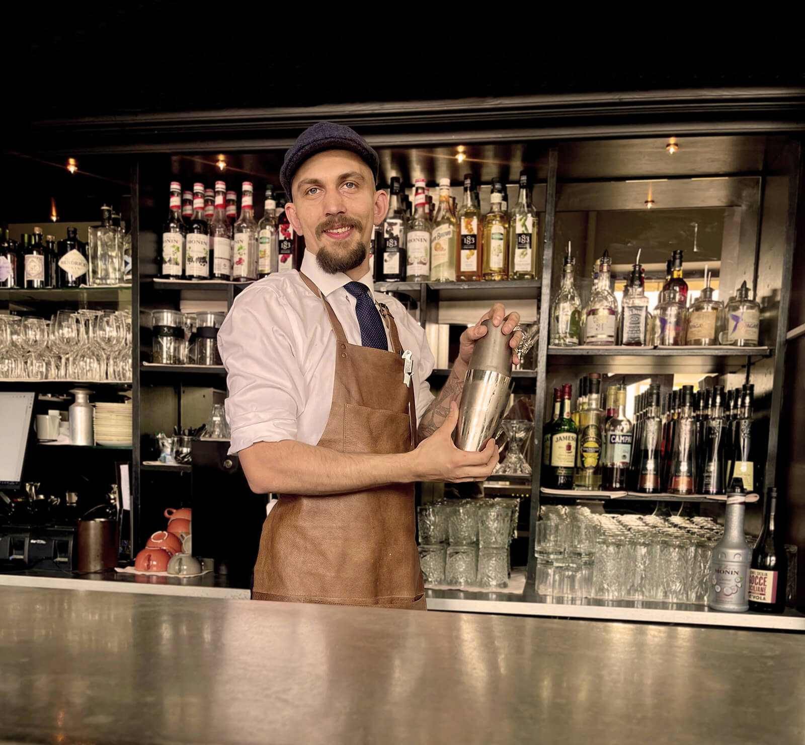 Bartender som står med en shaker ved en bardisk