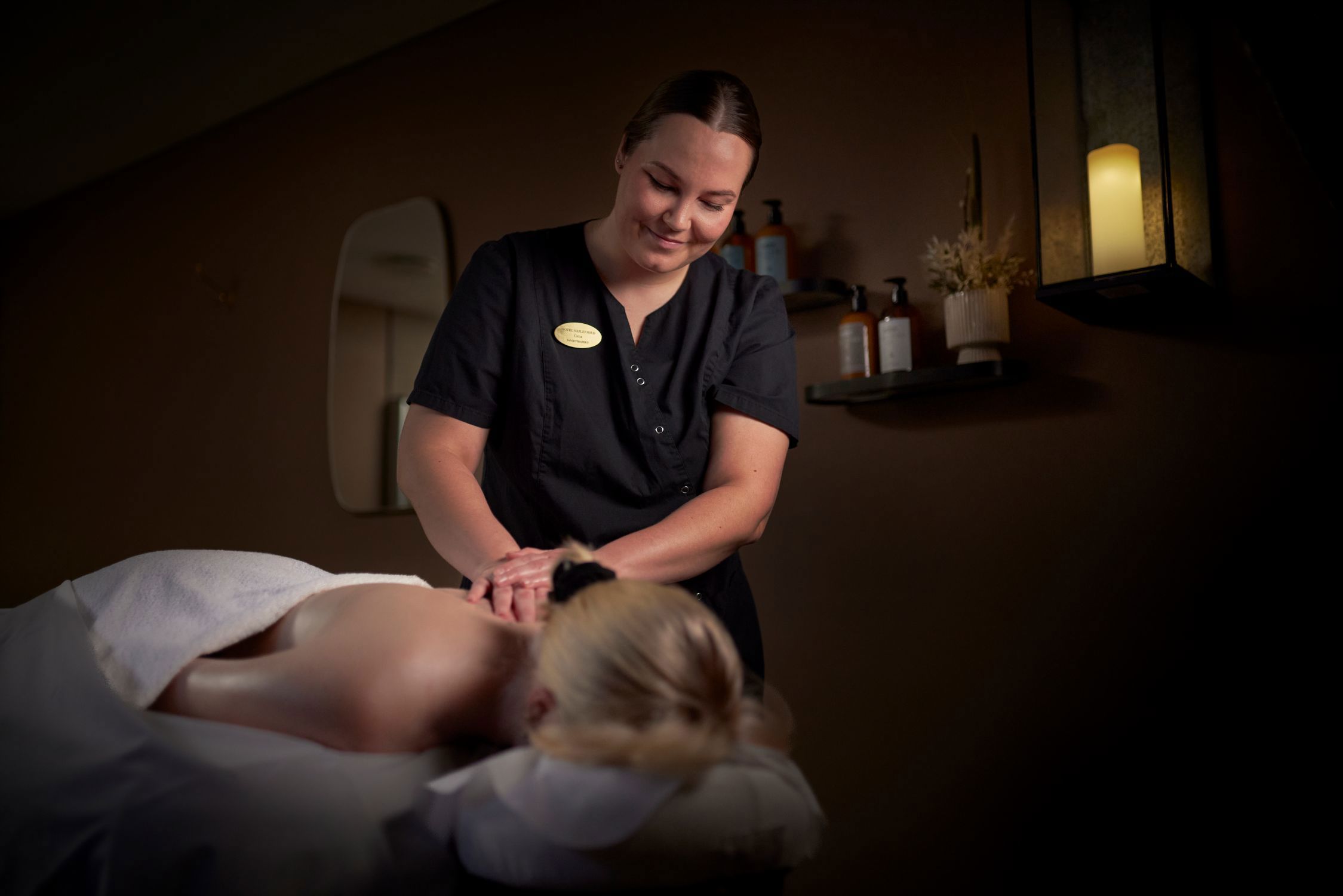 En kvinde ligger og får massage af en terapeut